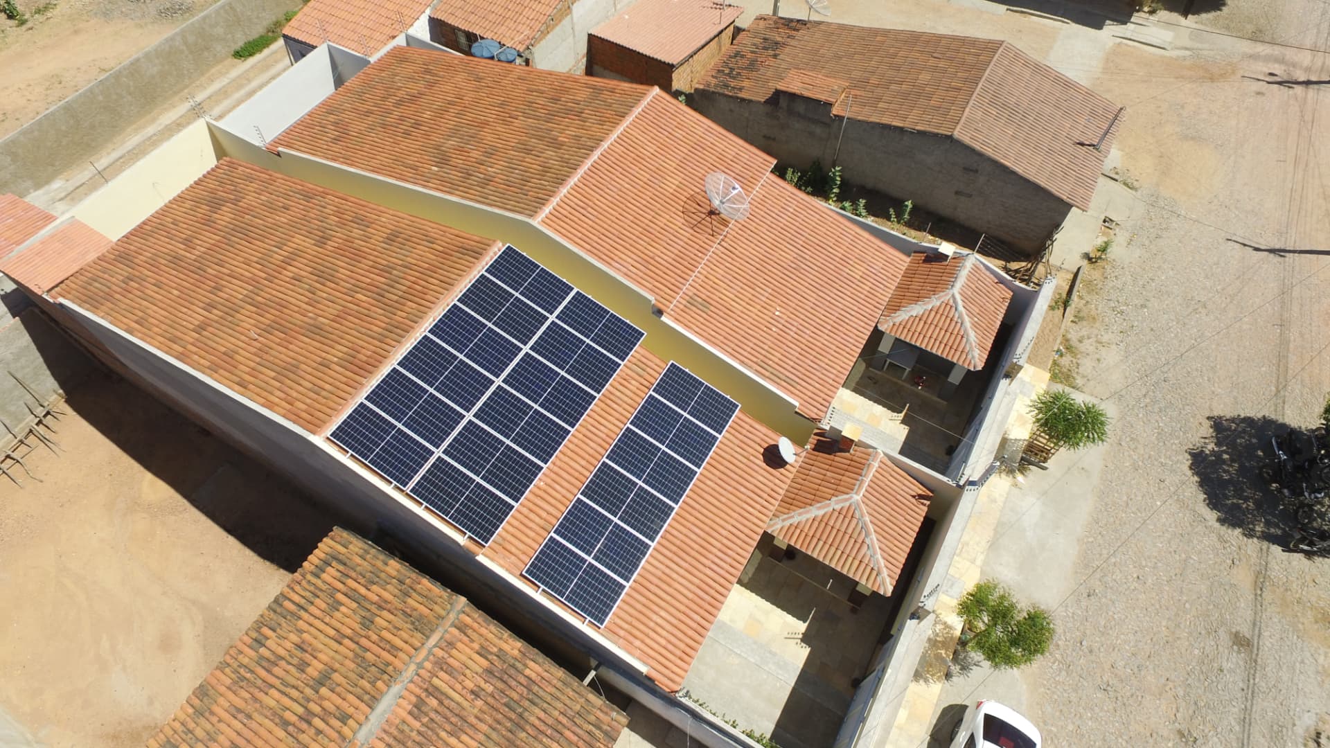 Vista aérea de módulos fotovoltaicos instalados em telhado residencial