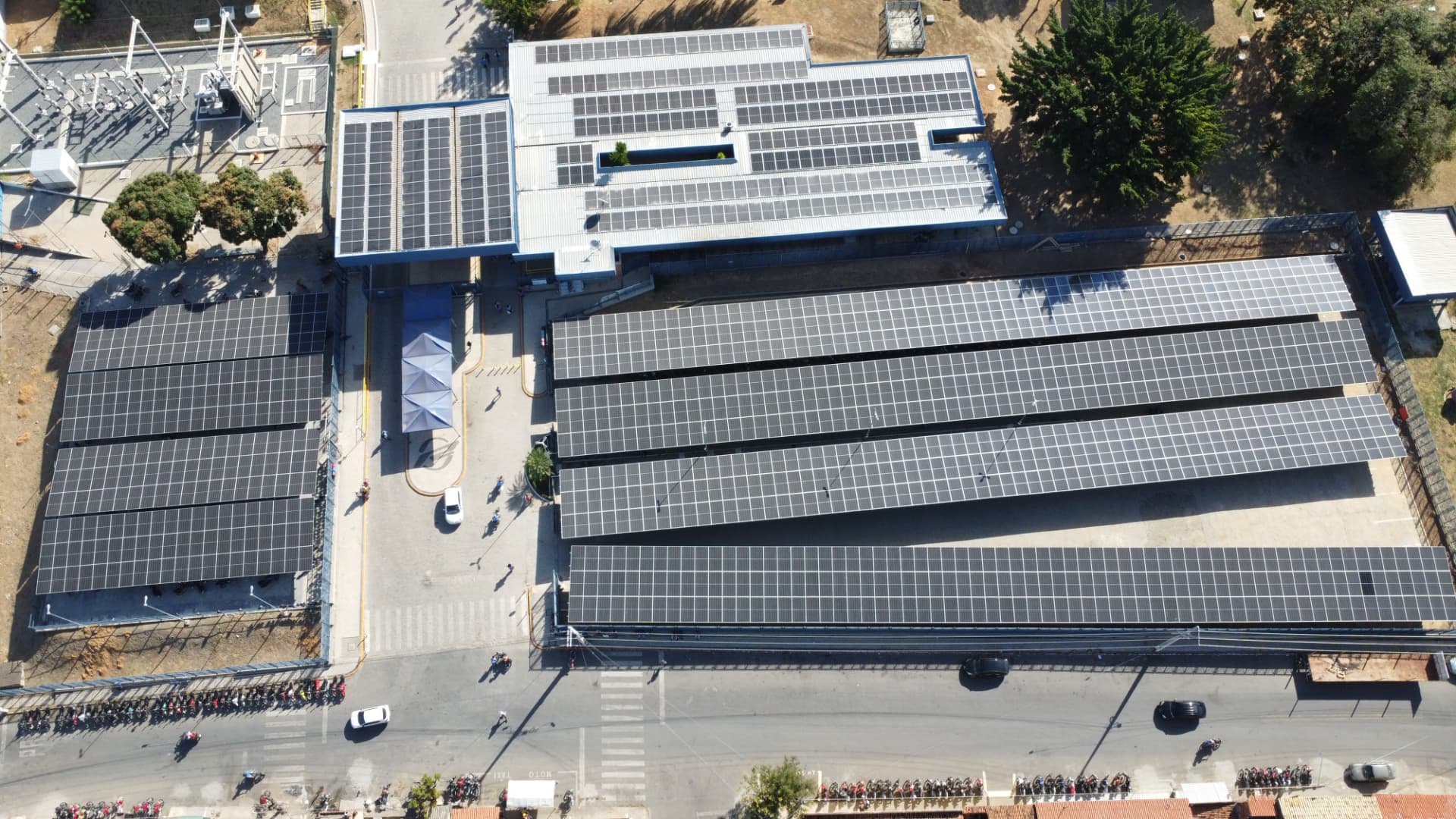 Vista aérea de módulos fotovoltaicos distribuídos em várias coberturas industriais