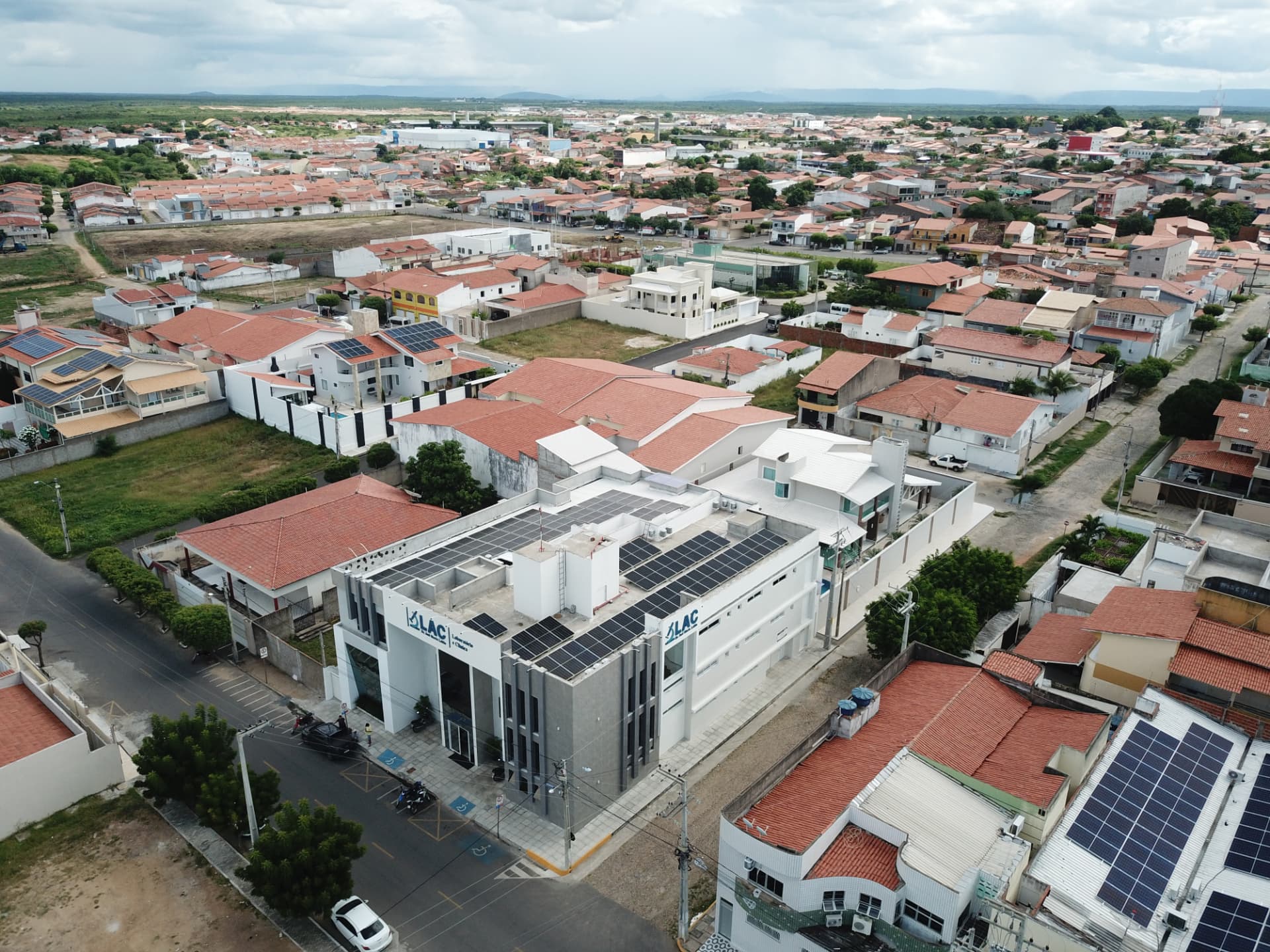 Vista aérea de edifício comercial urbano com módulos fotovoltaicos na cobertura