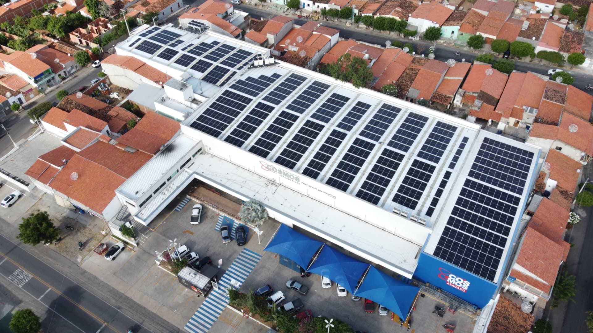 Vista aérea de uma grande instalação comercial coberta por módulos fotovoltaicos